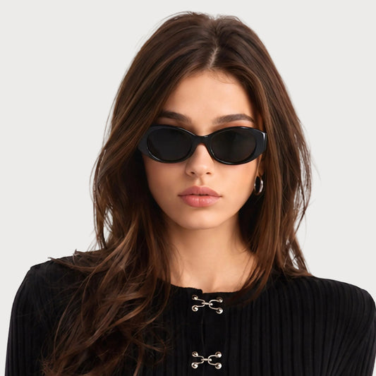 Model wearing Bella Black oval polarized sunglasses, front view on light gray