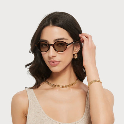 Model wearing Isla Brown Tortoise oval sunglasses, angled view