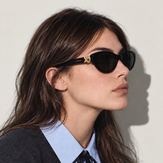 Mira Black sunglasses worn by a model, side view with gold temple detail.