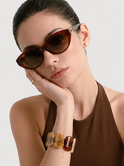 Model wearing Mira Caramel sunglasses on a light gray background.