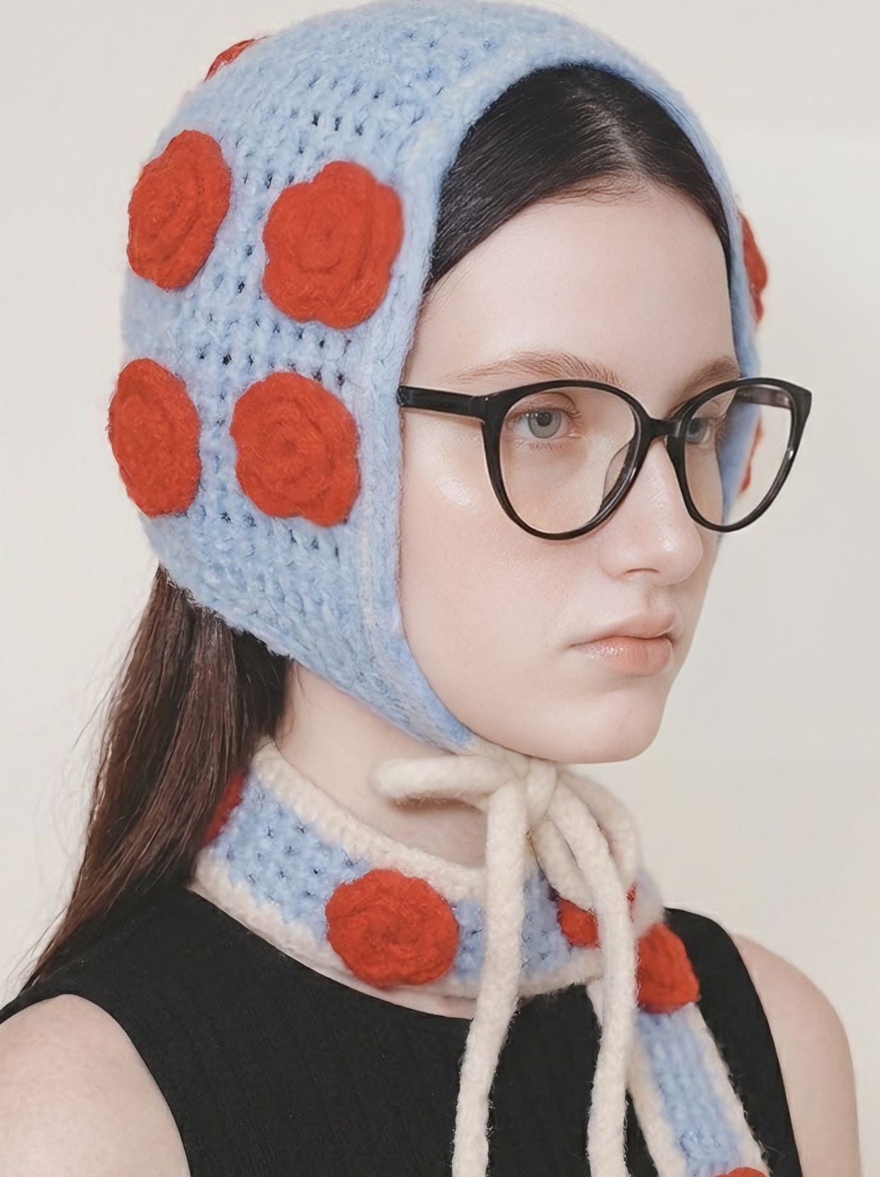 Model wearing Sienna Black cat-eye glasses in a blue knit hat, three-quarter editorial portrait