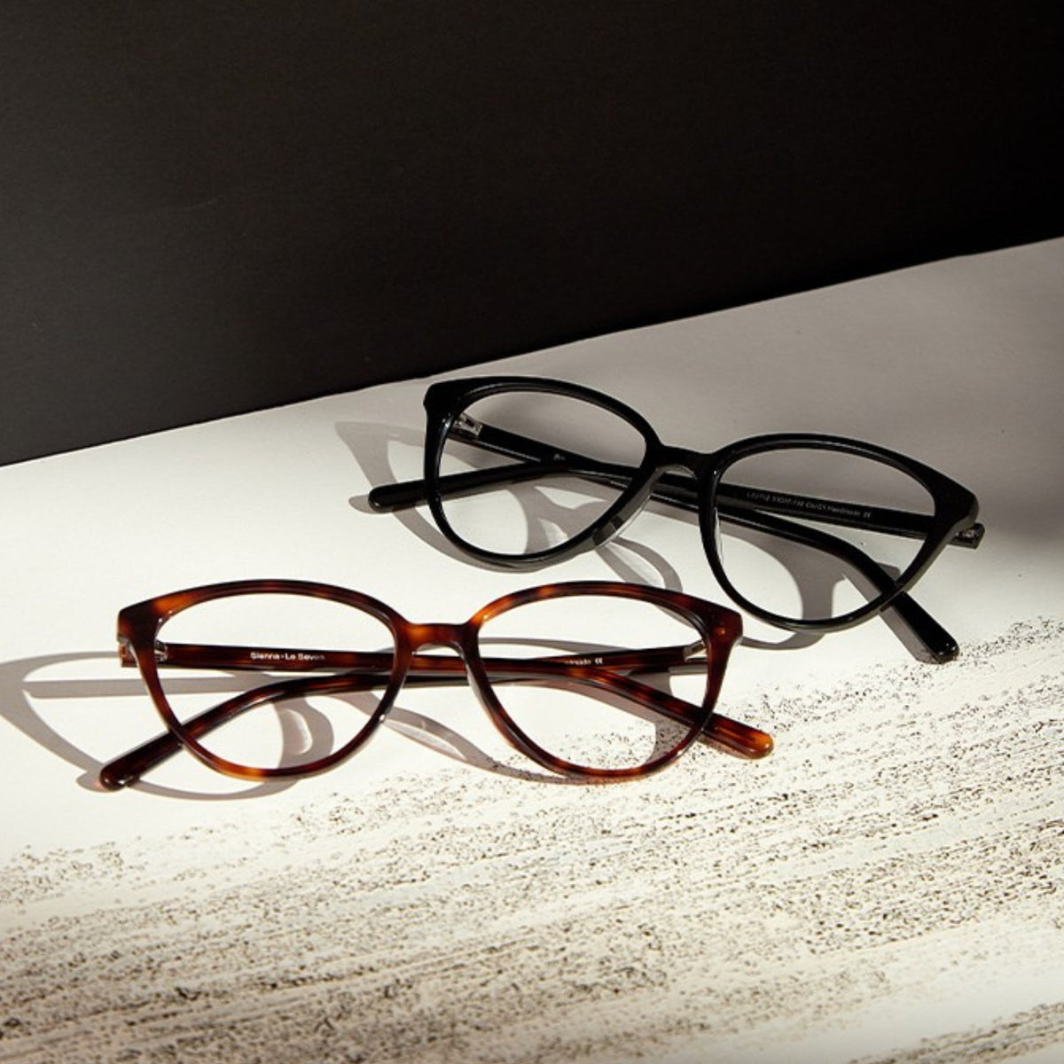Sienna Black and Brown Tortoise cat-eye glasses on a textured editorial surface