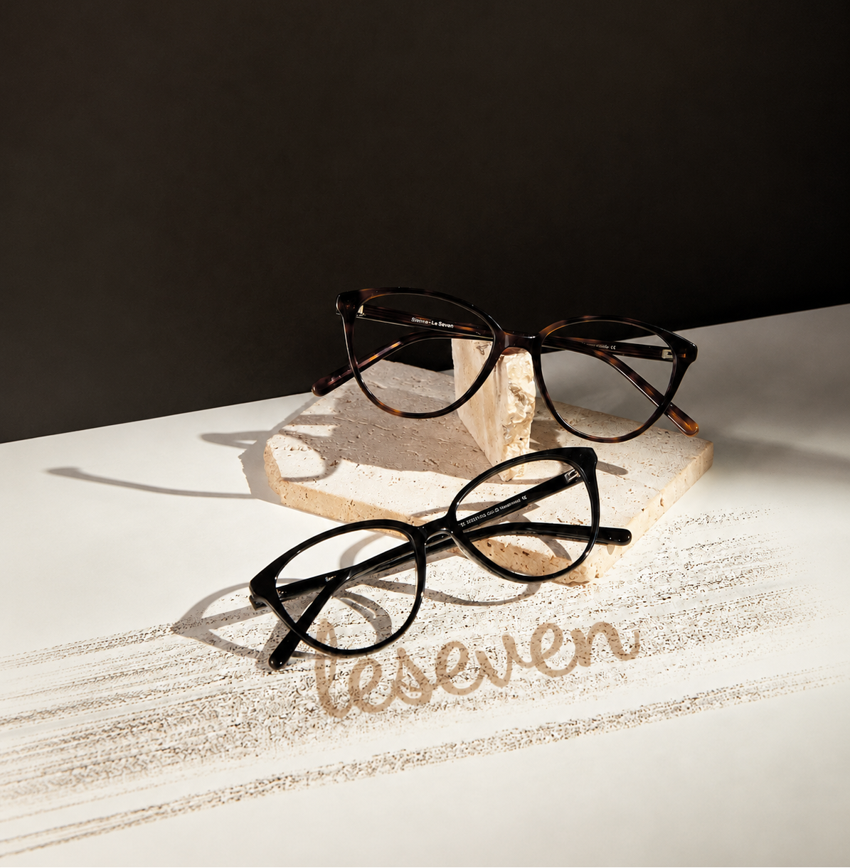 Sienna cat-eye optical frames in tortoise and black displayed on stone