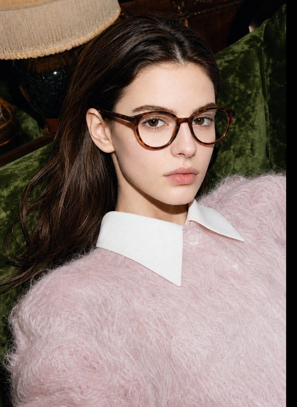 Model wearing Sienna tortoise eyeglasses in a textured interior