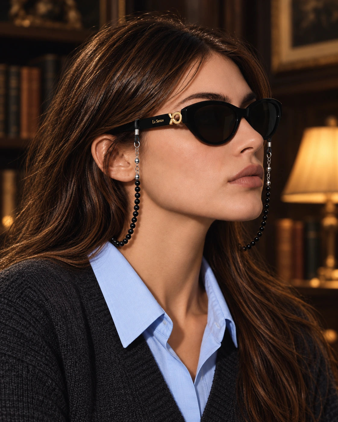 Mira Black sunglasses with the Black beaded eyeglass chain in a dark autumn library